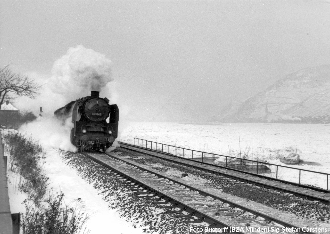 50 1543 im Februar 1956 auf der linken Rheinstrecke – im Hintergrund ist auf der anderen Rheinseite schwach die Dampfwolke eines ebenfalls südwärts fahrenden Zuges zu erkennen